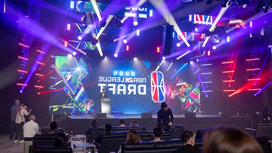 NBA 2K联盟首席执行官安德鲁·珀尔马特站在舞台前的大屏幕上，屏幕上有NBA 2K联盟选秀大会的标志.